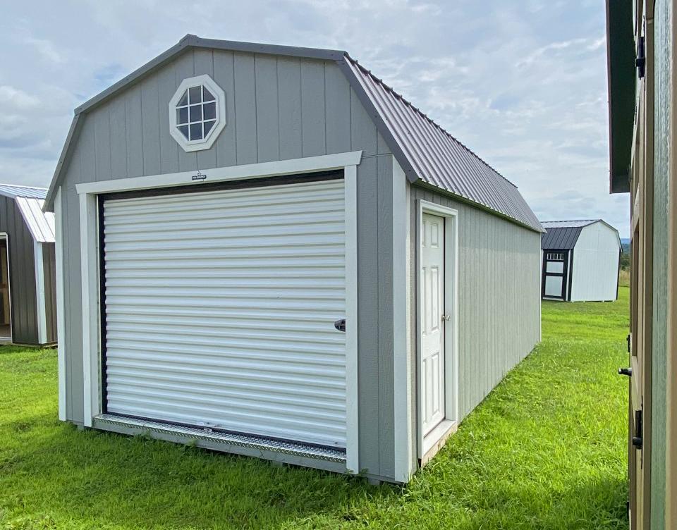 Large portable garage with white roll up garage door with fiberglass side entry door